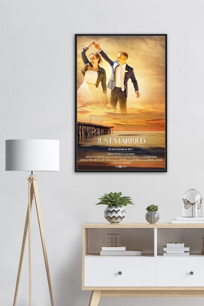 A part of a living room showing a cabinet, lamp and a personalized movie poster in a big black frame on the wall.